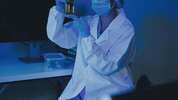 Young scientists conducting research investigations in a medical laboratory, a researcher in the foreground is using a microscope video