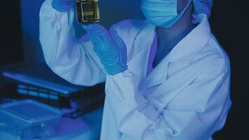 Young scientists conducting research investigations in a medical laboratory, a researcher in the foreground is using a microscope video