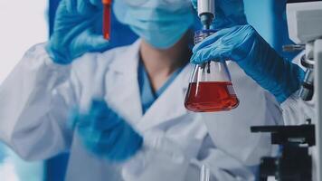 Young scientists conducting research investigations in a medical laboratory, a researcher in the foreground is using a microscope video