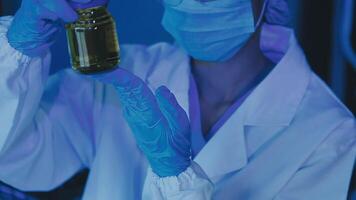 Young scientists conducting research investigations in a medical laboratory, a researcher in the foreground is using a microscope video