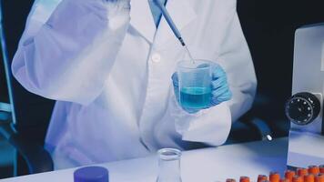 Young scientists conducting research investigations in a medical laboratory, a researcher in the foreground is using a microscope video