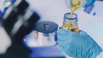 Young scientists conducting research investigations in a medical laboratory, a researcher in the foreground is using a microscope video