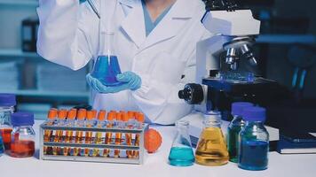 Young scientists conducting research investigations in a medical laboratory, a researcher in the foreground is using a microscope video