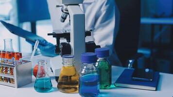 Young scientists conducting research investigations in a medical laboratory, a researcher in the foreground is using a microscope video