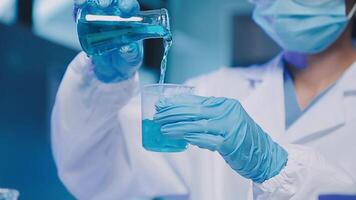 Young scientists conducting research investigations in a medical laboratory, a researcher in the foreground is using a microscope video