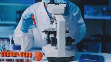 Young scientists conducting research investigations in a medical laboratory, a researcher in the foreground is using a microscope video