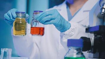 Young scientists conducting research investigations in a medical laboratory, a researcher in the foreground is using a microscope video