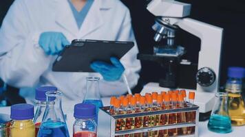 Young scientists conducting research investigations in a medical laboratory, a researcher in the foreground is using a microscope video