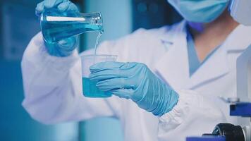 Young scientists conducting research investigations in a medical laboratory, a researcher in the foreground is using a microscope video