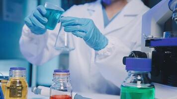 Young scientists conducting research investigations in a medical laboratory, a researcher in the foreground is using a microscope video