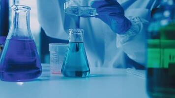 Young scientists conducting research investigations in a medical laboratory, a researcher in the foreground is using a microscope video