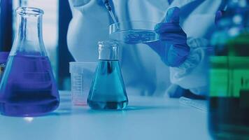 Young scientists conducting research investigations in a medical laboratory, a researcher in the foreground is using a microscope video