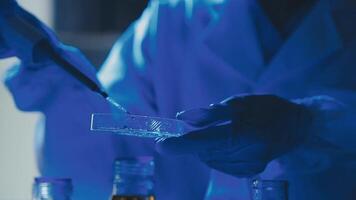 Young scientists conducting research investigations in a medical laboratory, a researcher in the foreground is using a microscope video