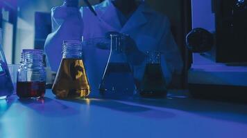 Young scientists conducting research investigations in a medical laboratory, a researcher in the foreground is using a microscope video