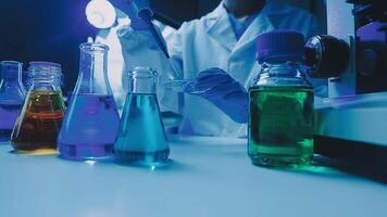 Young scientists conducting research investigations in a medical laboratory, a researcher in the foreground is using a microscope video