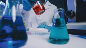 Young scientists conducting research investigations in a medical laboratory, a researcher in the foreground is using a microscope video