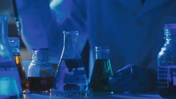 Young scientists conducting research investigations in a medical laboratory, a researcher in the foreground is using a microscope video