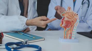 Group of doctors with laptop computer and clipboard with documents meeting and discussing at medical office. Nurse presenting symptoms of disease, colleagues taking notes during brainstorming. video