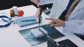 Group of doctors with laptop computer and clipboard with documents meeting and discussing at medical office. Nurse presenting symptoms of disease, colleagues taking notes during brainstorming. video