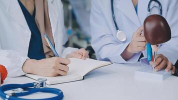 Group of doctors with laptop computer and clipboard with documents meeting and discussing at medical office. Nurse presenting symptoms of disease, colleagues taking notes during brainstorming. video