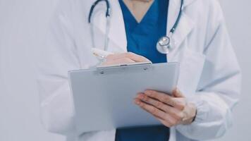 contenu Jeune femelle médecin posant à caméra. jolie femme portant blanc manteau et debout. médicament et soins de santé concept. isolé de face vue sur blanc Contexte. video