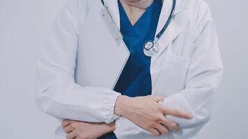 conteúdo jovem fêmea médico posando às Câmera. bonita mulher vestindo branco casaco e de pé. remédio e cuidados de saúde conceito. isolado frente Visão em branco fundo. video