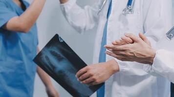 qualificato donna medico nel bianca uniforme controllo raggi X film, diagnosticare paziente lesione, sorridente calma e in piedi isolato su studio sfondo con copia spazio. assistenza sanitaria e medico assicurazione concetto video