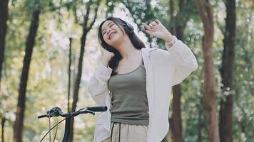 attraente giovane donna nel un' cappello equitazione un' bicicletta nel un' parco. attivo le persone. all'aperto video