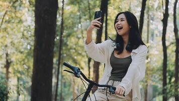 attraente giovane donna nel un' cappello equitazione un' bicicletta nel un' parco. attivo le persone. all'aperto video