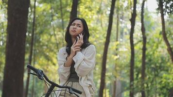 Attractive young woman in a hat riding a bicycle in a park. Active people. Outdoors video