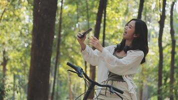 atractivo joven mujer en un sombrero montando un bicicleta en un parque. activo gente. al aire libre video