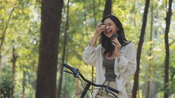 attraente giovane donna nel un' cappello equitazione un' bicicletta nel un' parco. attivo le persone. all'aperto video