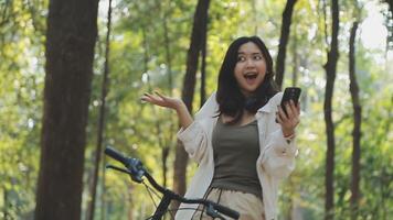 atractivo joven mujer en un sombrero montando un bicicleta en un parque. activo gente. al aire libre video