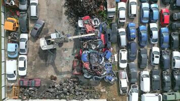 grua levantamiento chatarra metal carros en un depósito de chatarra. video