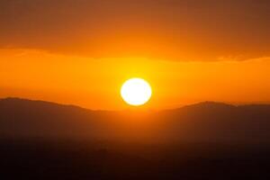 Sunset sky with sun and clouds photo