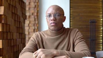 An african american man looks out the window. Aesthetics of caramel color. Stylish man in casual outfit video