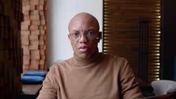 An african american man is negotiating remotely through a video chat looking at the camera