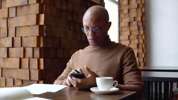 Young african american business man with freckles on his face typing on a smartphone. video