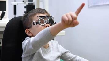 The boy sits in a chair at an ophthalmologist's appointment and follows the doctor's instructions video