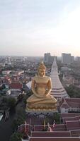 Riese golden Buddha beim Sonnenuntergang mit ein schön Stadt Horizont im das Hintergrund. video