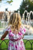 Small girl in beautiful dress admiring fountain in Verona Italy photo