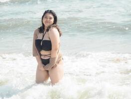 Portrait young asian woman fat chubby cute beautiful smile happy fun enjoy relax bikini swimwear body sexy front view sea beach white sand clean bluesky calm nature ocean wave water travel on holiday photo