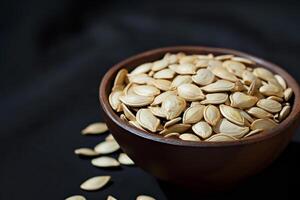 AI generated Pumpkin seeds in a small bowl on black background. photo