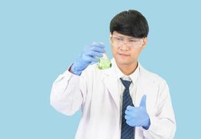 asiático hombre estudiante científico o médico en reactivo mezcla laboratorio en un Ciencias investigación laboratorio con prueba tubos de varios tamaños en el piso en laboratorio química laboratorio azul antecedentes. foto