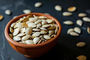 AI generated Pumpkin seeds in a small bowl on black background. photo