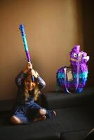 retrato de un cumpleaños niña con un murciélago planificación a descanso lama piñata foto