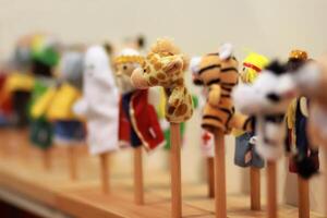 Toy puppets on wooden sticks for preschool nursery theatre, standing in a row. Puppet theatre art. photo