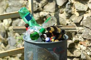 Trash bin  garbage can overflowing empty bottles photo