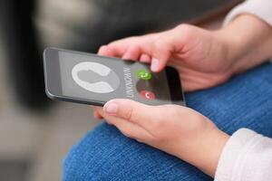 Close up of woman's hands with smartphone and unknown incoming phone call on it, fraud or scam schemes photo