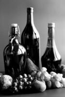 Black and white autumn still life with wine bottles and fruits. Selective focus photo